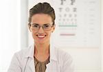 Doctor woman in eyeglasses in front of snellen chart