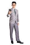 Full body of a young Asian business man using smart phone, texting and looking at the phone with a smile on his face, isolated on white background.