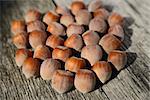 Several hazelnuts in shell on a wooden background