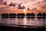 Maldives  sunset with water villas silhouette