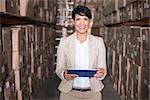 Pretty warehouse manager holding tablet pc in a large warehouse