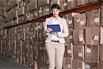 Pretty warehouse manager using tablet pc in a large warehouse