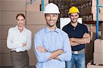 Warehouse team smiling at camera in a large warehouse