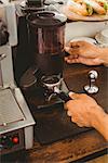 Barista grinding fresh coffee beans at the coffee shop