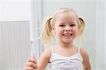 Cute girl brushing her teeth at home in the bathroom