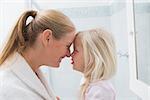 Happy mother and daughter smiling at home in the bathroom