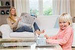 Cute daughter using laptop on coffee table at home in the living room