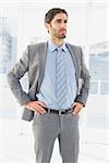 Businessman thinking about work with hands on hips