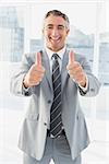 Businessman looking at the camera giving a thumbs up