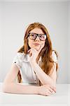 Pretty redhead thinking and looking up on white background