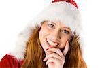 Festive redhead with hand on chin on white background