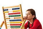 Cute little girl using an abacus on white background