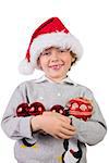 Child wearing a santa hat and holding baubles