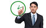 Composite image of serious asian businessman pointing to a clock on white background