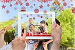 Hands holding tablet pc against parents giving children a piggyback