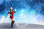 Sexy santa girl pointing against snowy landscape with fir trees