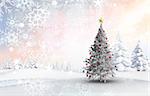 Christmas tree with baubles and star against snowy landscape with fir trees