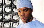 2000s PORTRAIT OF AFRICAN AMERICAN DOCTOR WEARING SCRUBS LOOKING AT CAMERA WITH BODY SCANS IN BACKGROUND