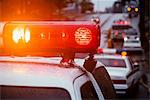 CLOSE-UP OF RED LIGHTS ON TOP OF EMERGENCY VEHICLES AT ACCIDENT SITE AT DUSK