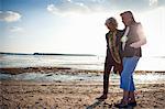 Mother and daughter walking on beach