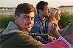 Four adult friends sitting on Bournemouth beach, Dorset, UK