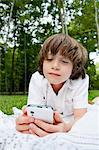 Boy lying on front reading messages on smartphone