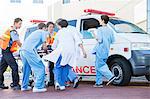 Doctors, nurses, and paramedic examining patient on stretcher