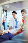 Doctor and paramedic examining patient in ambulance