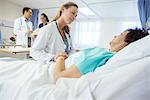 Doctor talking to patient in hospital bed