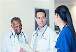 Doctors and nurse talking in hospital hallway