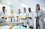 Doctor and residents examining patient in hospital bed