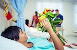 Patient admiring bouquet of flowers in hospital room