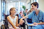 Nurse holding patient's hands in hospital