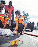 Paramedics examining injured girl on street