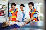 Doctor and paramedics examining patient in ambulance