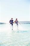 Couple splashing in water on beach