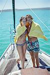 Couple sharing towel in boat on water