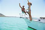 Couple jumping off boat together