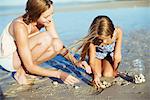 Mother and daughter playing in sand