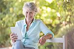 Older woman using digital tablet outdoors
