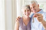 Older man holding keys with wife