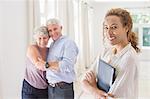 Older couple hugging with woman smiling