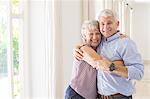 Older couple hugging in living space