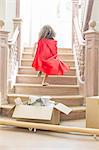 Young girl running up stairs playing