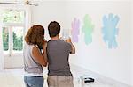 Couple taking picture on wall with digital tablet