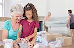 Grandmother and granddaughter going through moving box