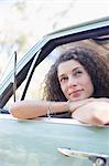 Woman relaxing on car door during car ride