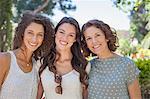 Mother and daughters hugging outdoors