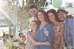 Family hugging outdoors on sunny day