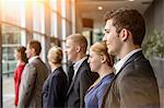 Group of smiling businesswomen and men standing in a row